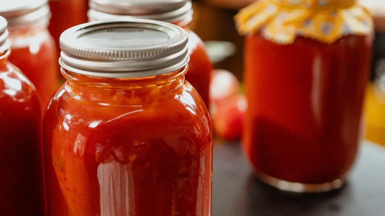 Plusieurs bocaux remplis de coulis de tomates maison, prêts à être dégustés.