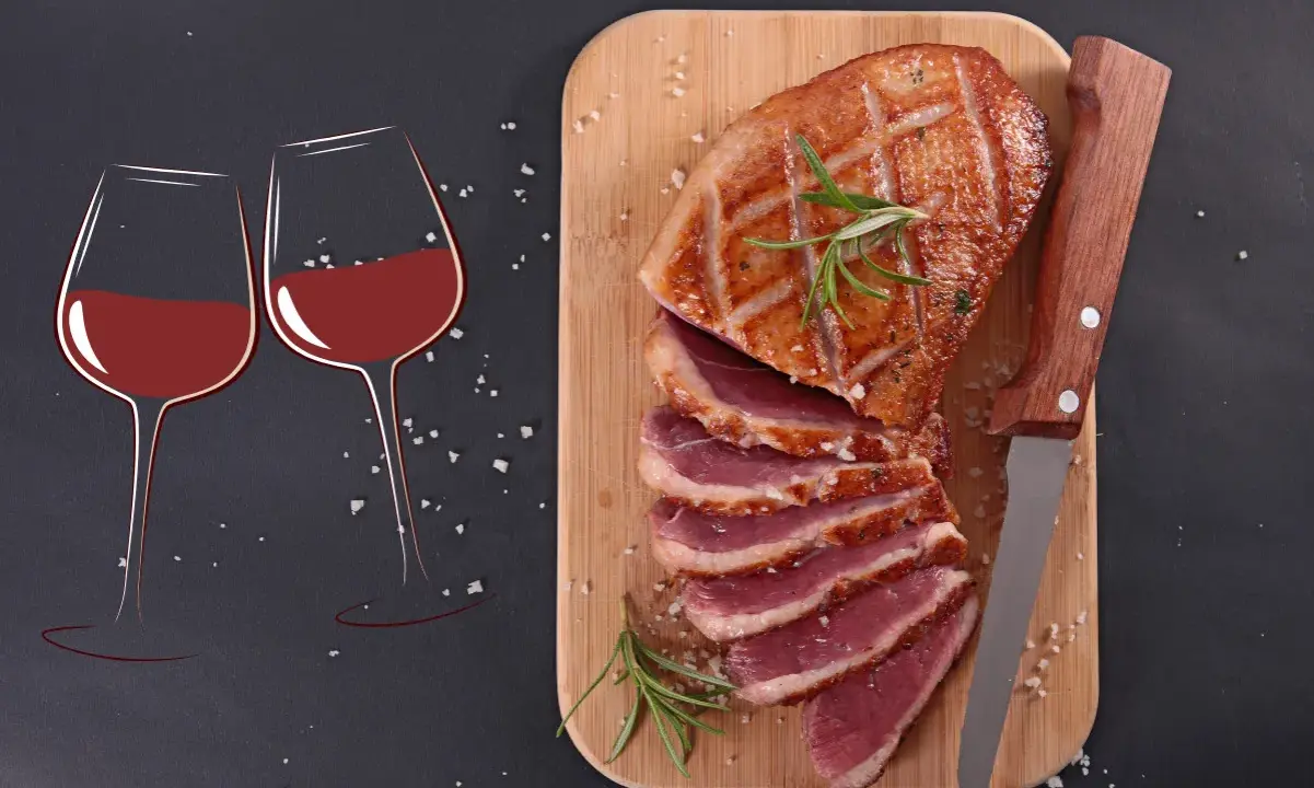 Quel vin avec magret de canard ? Deux verres de vin rouge et un magret de canard tranché sur une planche en bois, prêts à être dégustés.