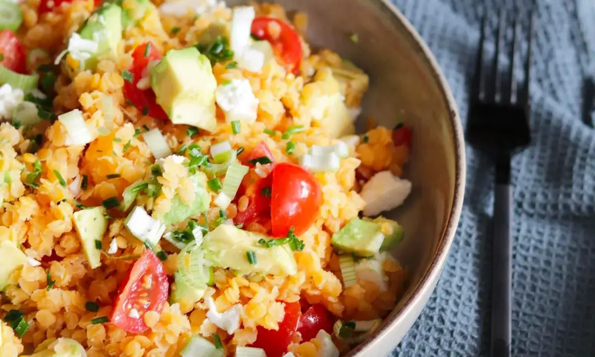 Salade colorée de lentilles corail, avocat, tomates cerises et feta. Un plat frais et nutritif, parfait pour un repas léger.