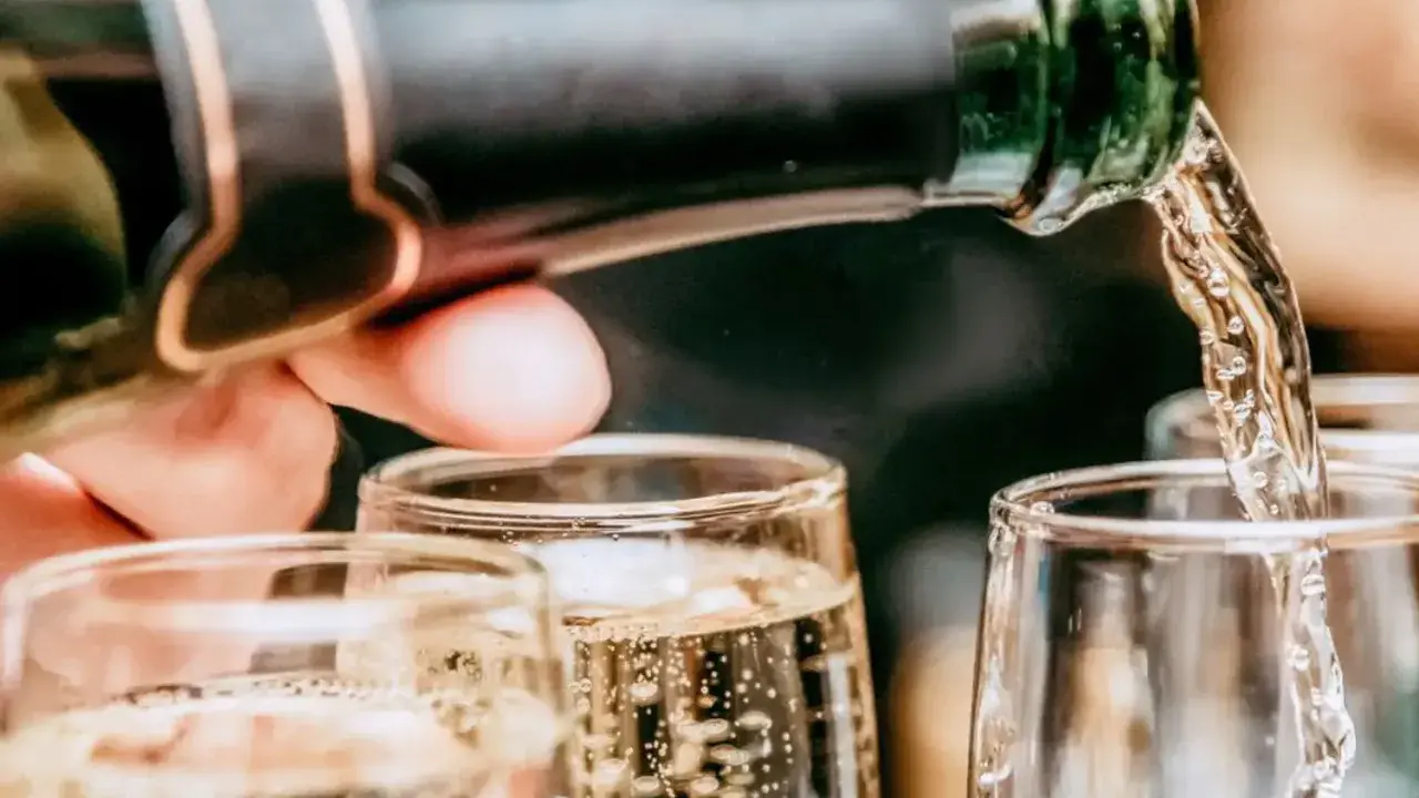 Un verre se remplit de bulles fines, promesse du meilleur champagne rosé. Une célébration pétillante commence.