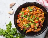 Un bol de chili sin carne, garni de persil frais. Des haricots rouges, du maïs et des dés de poivrons se mêlent à la viande hachée dans cette recette réconfortante.