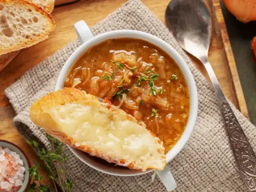 Une délicieuse recette de soupe à l'oignon, gratinée avec du fromage fondant sur une tranche de pain croustillant.