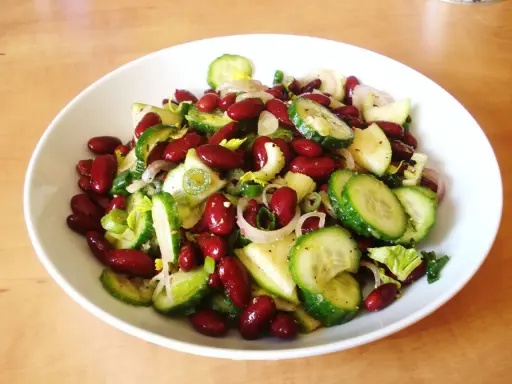 Salade colorée de haricots rouges, concombre, oignon rouge et céleri, prête à être dégustée.