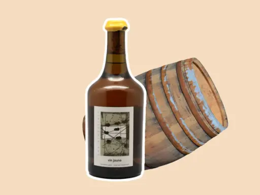 Bouteille de vin jaune à côté d'un vieux fût de chêne. Le vin jaune, une spécialité du Jura, est un vin oxydatif unique.