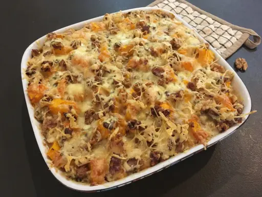 Gratin de courge butternut et noix, gratiné au fromage, avec des touches de Fourme d'Ambert pour une saveur unique.