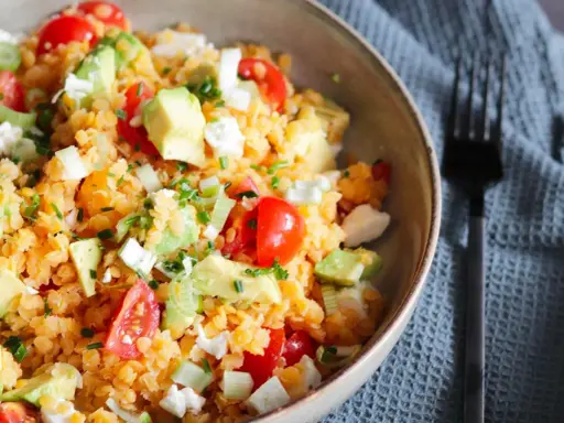 Salade colorée de lentilles corail, avocat, tomates cerises et feta. Un plat frais et nutritif, parfait pour un repas léger.