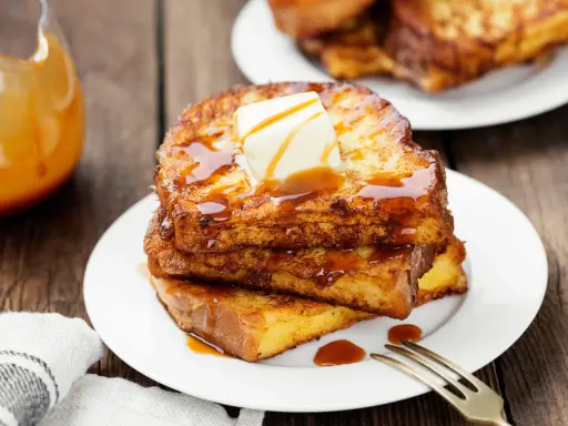 Pile de pain perdu salé doré, nappé de sirop et garni de beurre fondant. Un délice pour le petit-déjeuner.