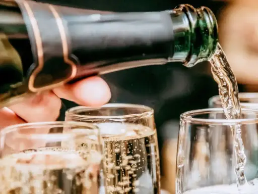 Un verre se remplit de bulles fines, promesse du meilleur champagne rosé. Une célébration pétillante commence.