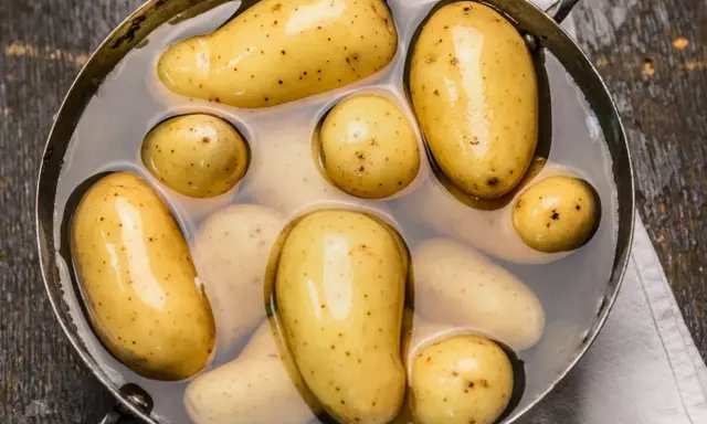 Des pommes de terre nouvelles dans une casserole d'eau, prêtes pour une délicieuse recette de pomme de terre.