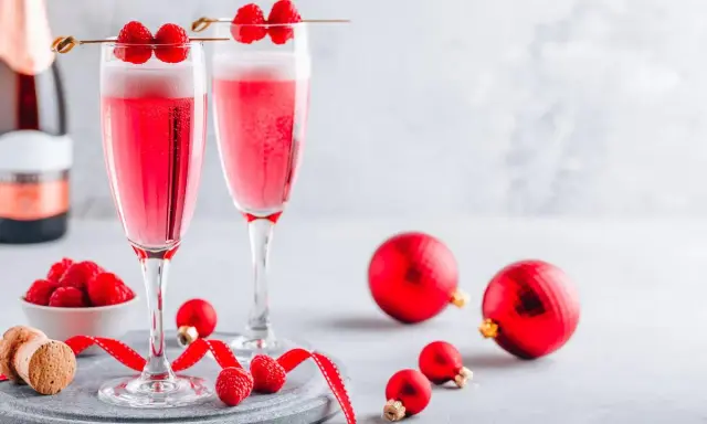 Deux coupes de soupe champenoise framboise pétillante, décorées de fruits rouges frais, prêtes pour les fêtes.