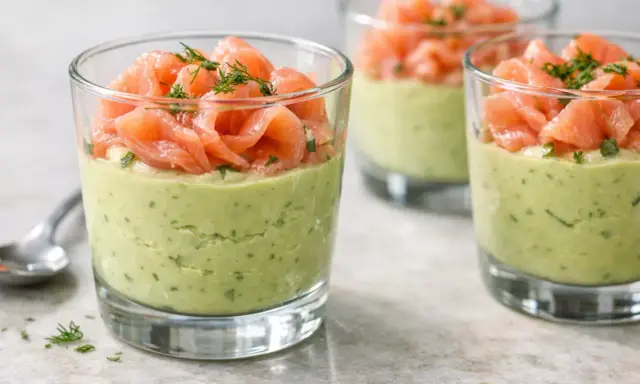 Verrine avocat saumon : une couche crémeuse d'avocat et d'herbes surmontée de fines tranches de saumon fumé, garnie d'aneth.