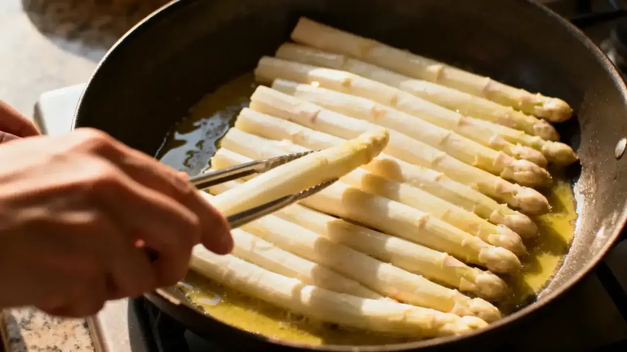 Une recette asperge blanche en préparation : des asperges blanches sont saisies dans une poêle avec du beurre.