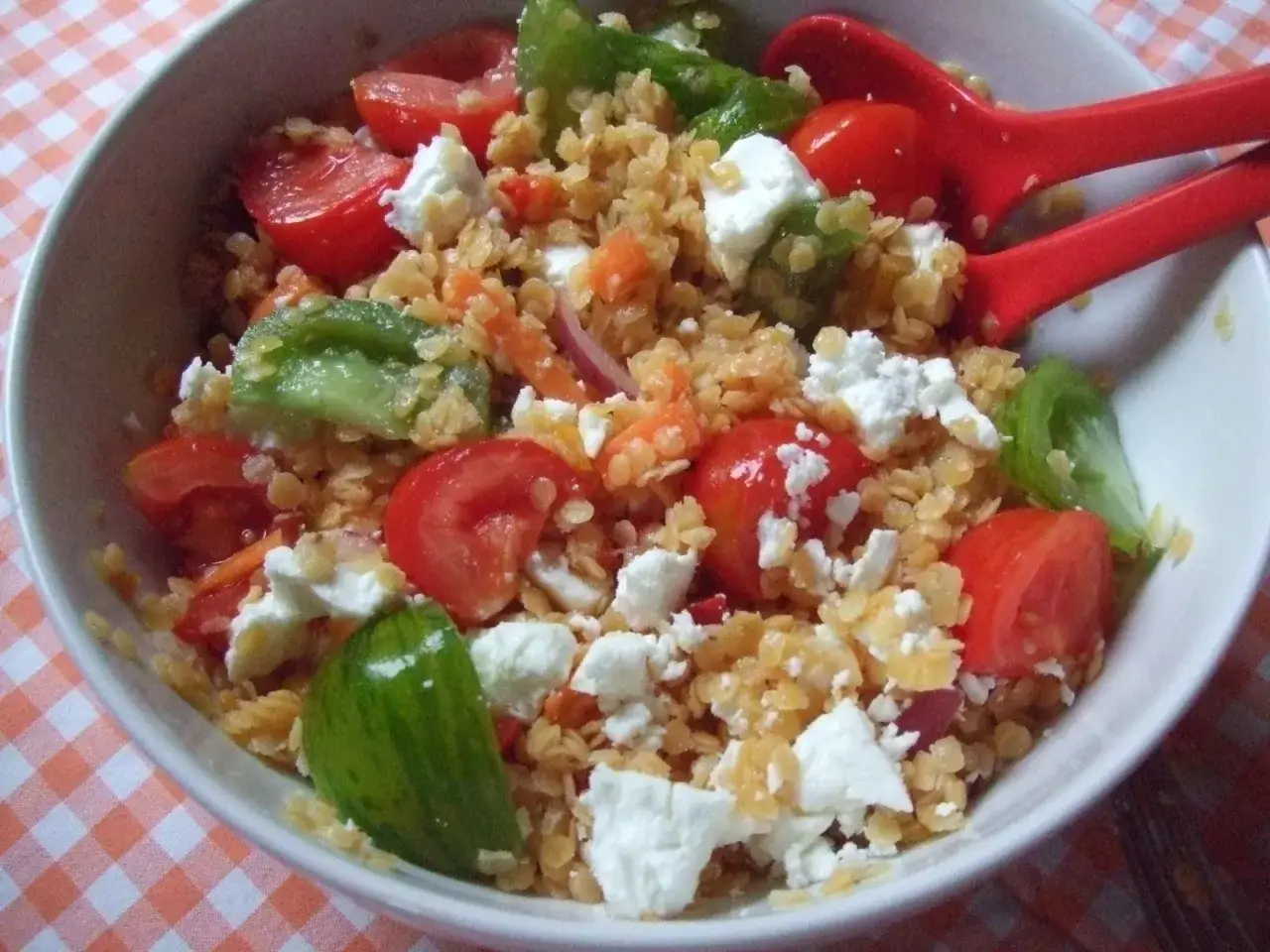 Salade colorée de lentilles corail, tomates cerises, concombre et feta émiettée. Un délice frais et léger pour un repas sain.