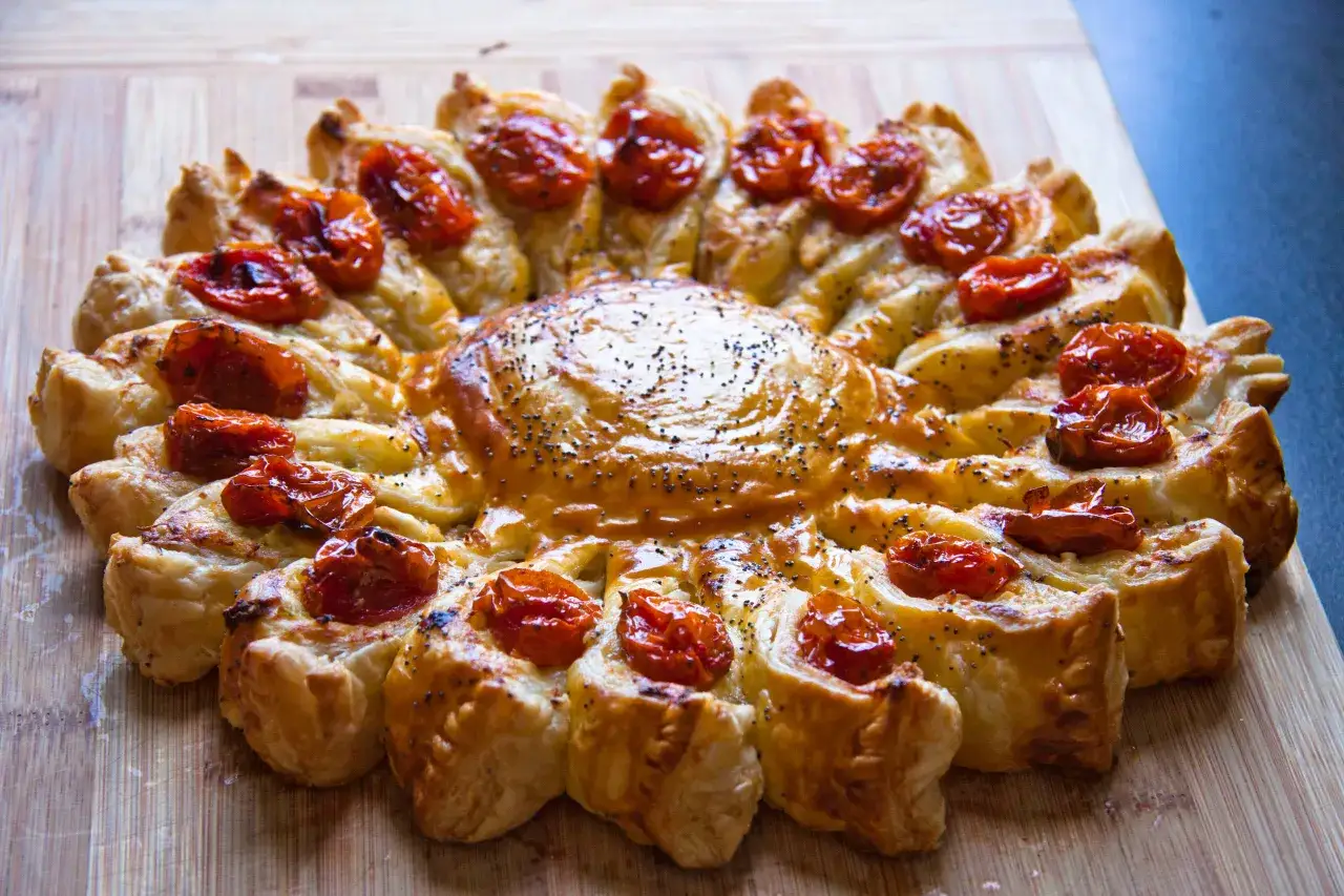 Tarte feuillet&eacute;e en forme de soleil, garnie de tomates cerises confites et de graines de pavot. Parfaite recette ap&eacute;ro rapide pour &eacute;pater vos invit&eacute;s !