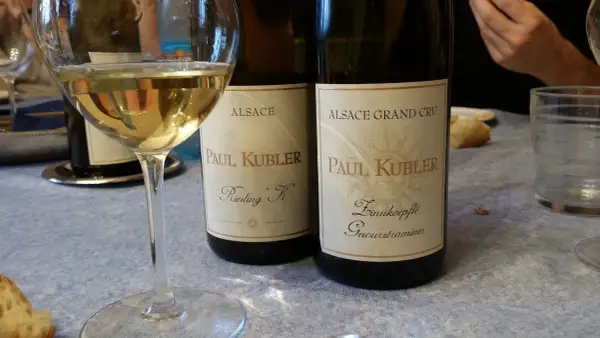 Verre de vin blanc et deux bouteilles Paul Kubler, Riesling et Gewurztraminer. Quel vin pour cuire la choucroute ? Le Gewurztraminer est un excellent choix.